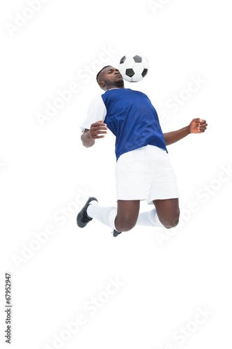 Fototapeta Naklejka Na Ścianę i Meble -  Football player in blue jersey controlling ball