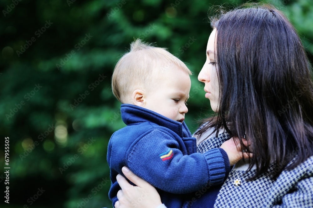 Fototapeta premium Young mother holding her son