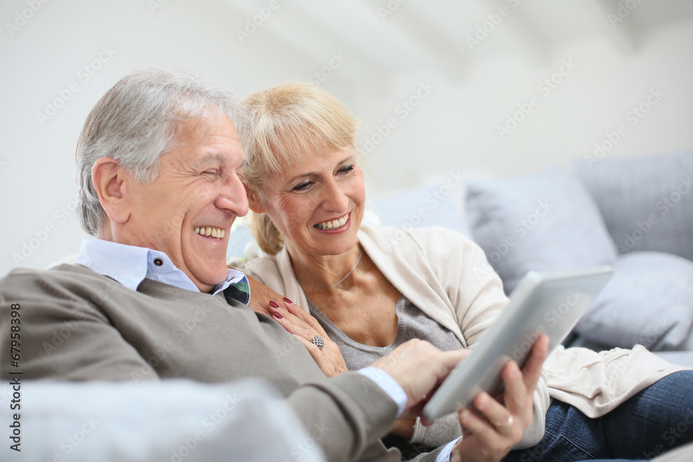 Cheerful senior people websurfing on internet with tablet