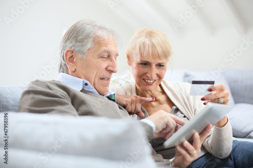 Senior couple e-shopping with digital tablet
