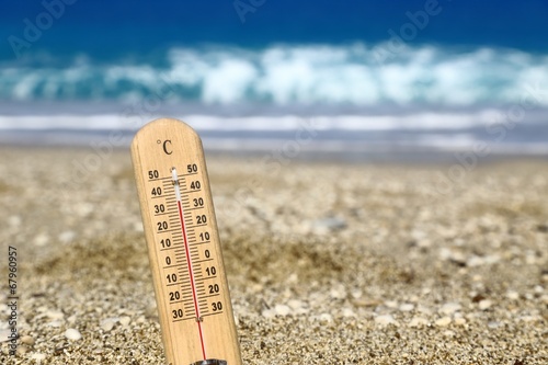 Thermometer on a beach shows high temperatures