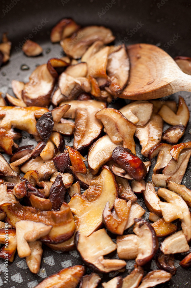 Funghi porcini affettati rosolati in padella Funghi porcini affettati rosolati in padella