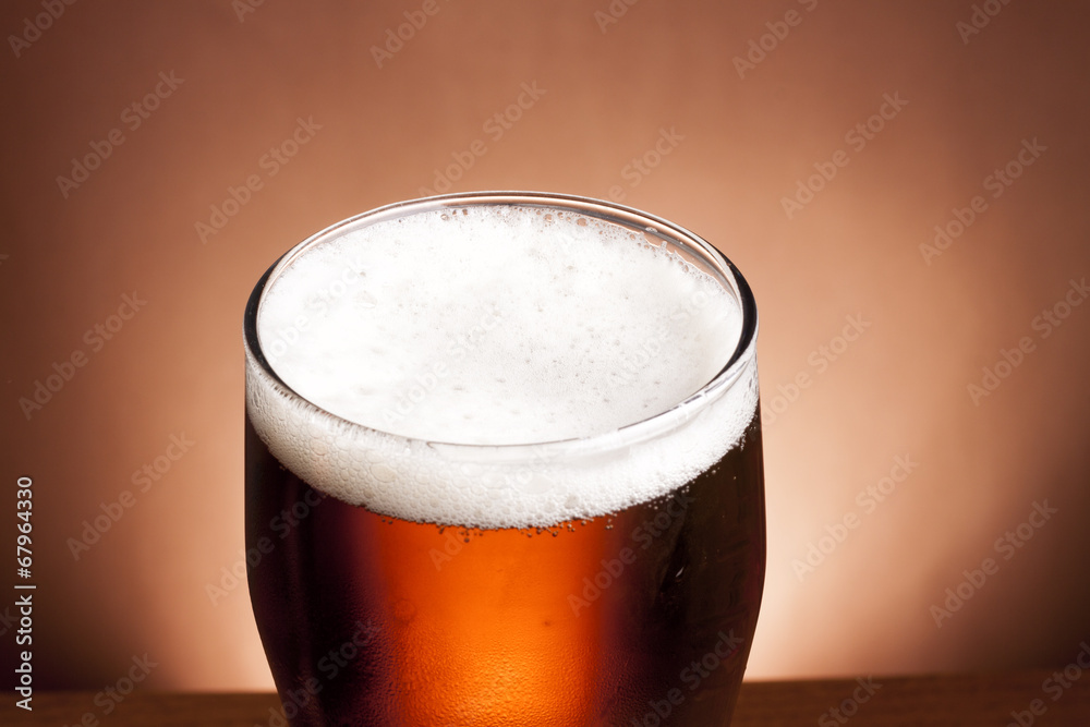 glass of beer on a brown background glass of beer on a brown background