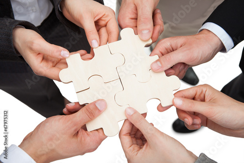 Business People Fixing Jigsaw Pieces