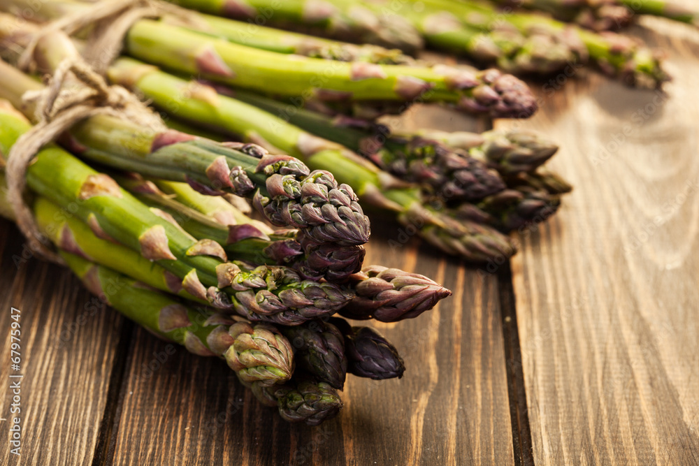 Bunch of young asparagus on wooden table Bunch of young asparagus on wooden table