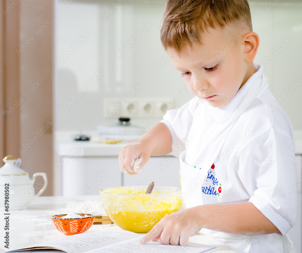 Little boy learning to bake reading the recipe Little boy learning to bake reading the recipe
