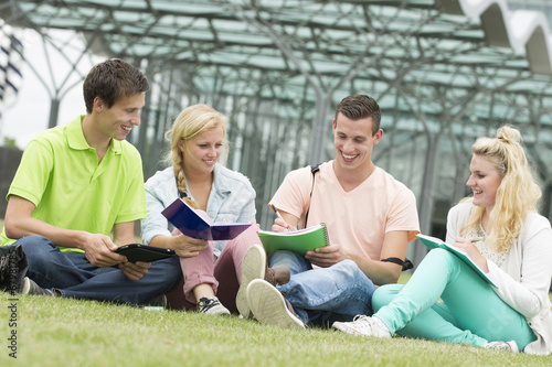 Four students learning while sitting on the ground