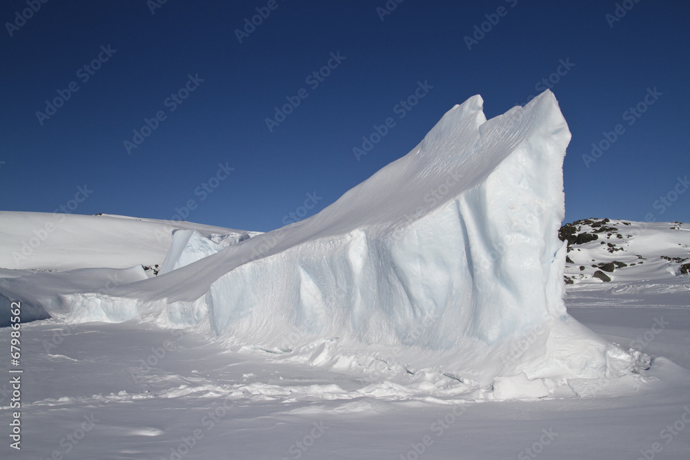 elongated iceberg frozen in Antarctic islands winter day
