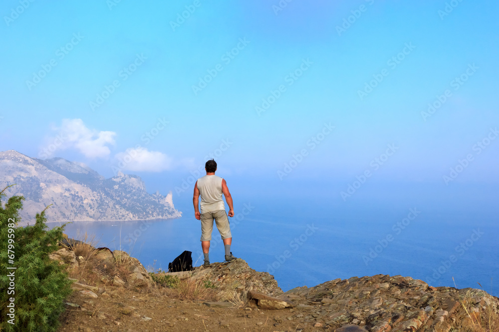 Traveler looks at the beautiful seascape from the mountain top