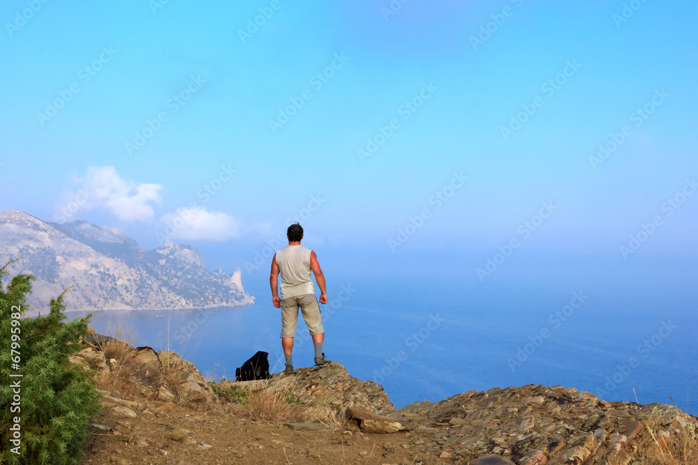 Obraz premium Traveler looks at the beautiful seascape from the mountain top