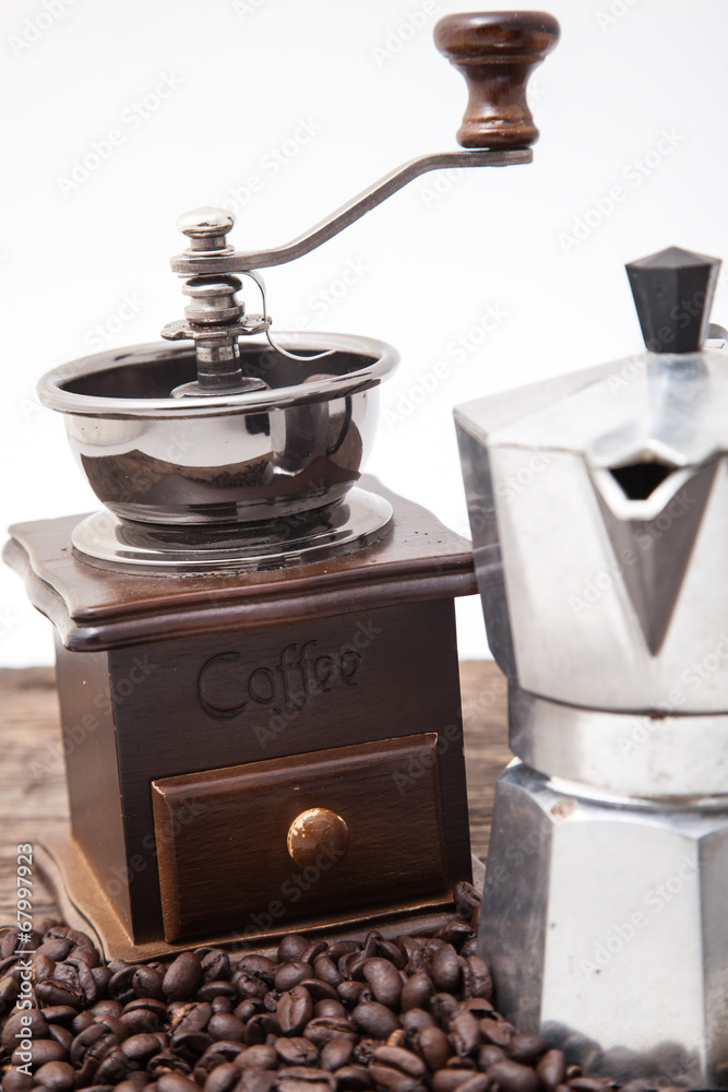 Isolated coffee bean grinder and moka pot on wooden table top Isolated coffee bean grinder and moka pot on wooden table top