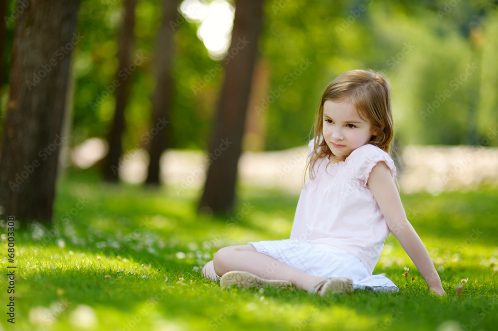 Cute little girl sitting on a clover field Cute little girl sitting on a clover field