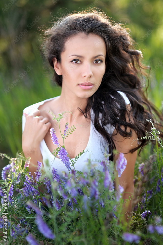 beautiful girl in a field with blooming flowers