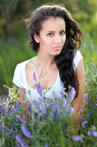 beautiful girl in a field with blooming flowers