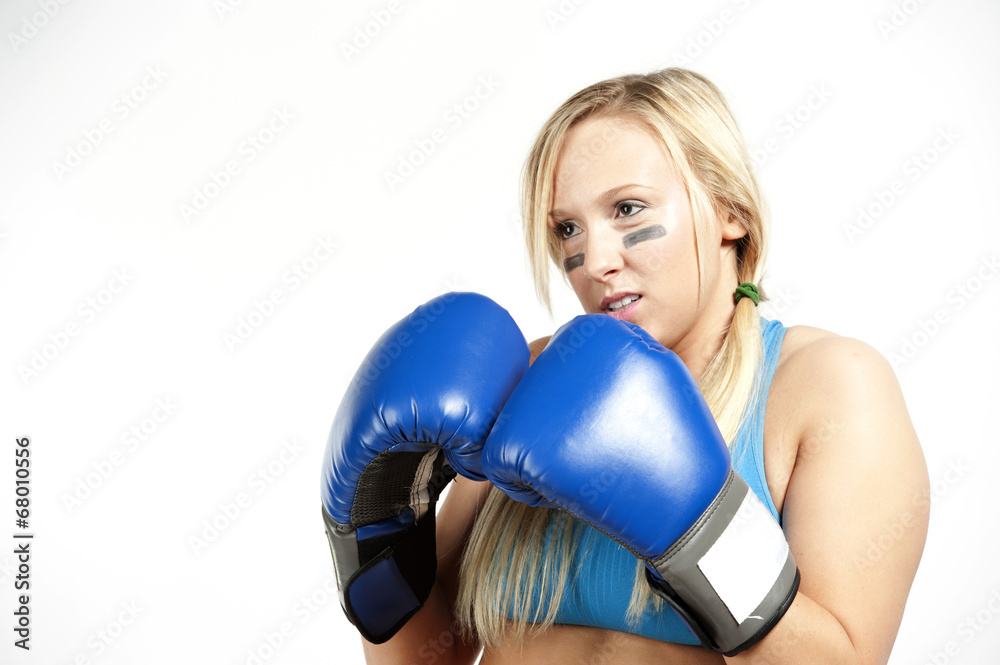 A young blond female boxer boxing in gloves on a white background wearing a blue sports bra. A young blond female boxer boxing in gloves on a white background wearing a blue sports bra.