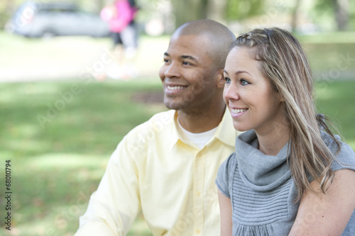 Happy young interracial couple posing together on a sunny day.