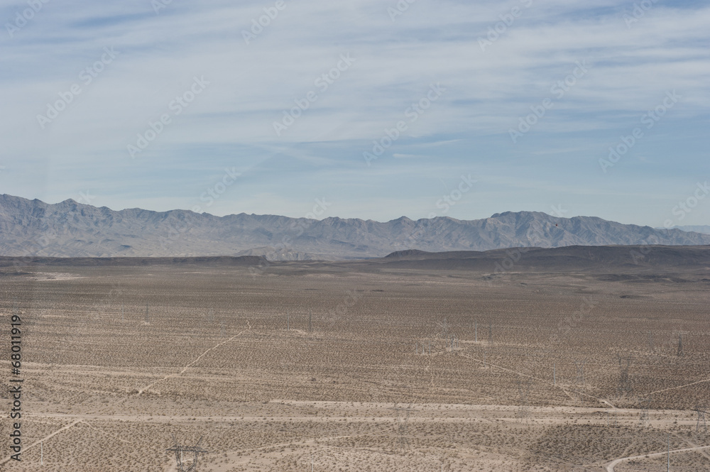 A dry desert view on a sunny day from a helicopter.