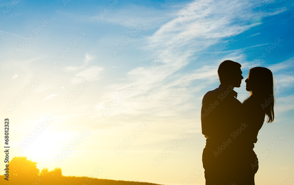 Young couple enjoying the sunset. Two silhouettes.