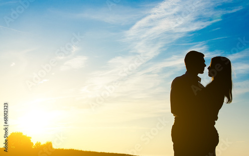 Young couple enjoying the sunset. Two silhouettes.