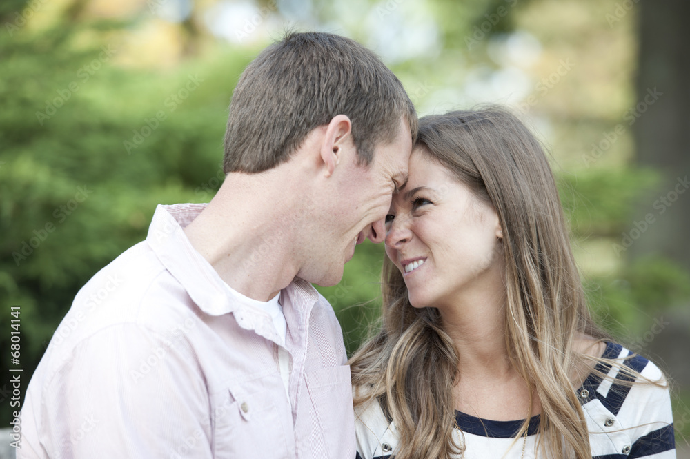 Happy young caucasian couple sitting at the park both hugging and smiling. Happy young caucasian couple sitting at the park both hugging and smiling.