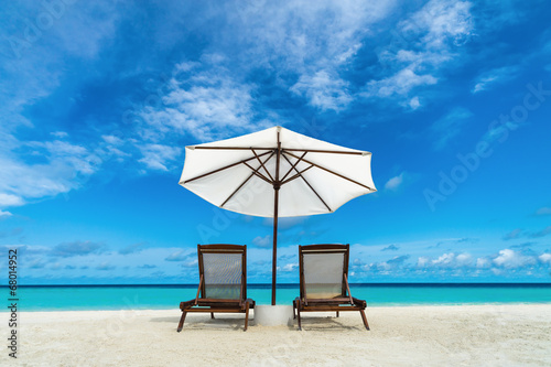 Beach lounger and umbrella on sand beach