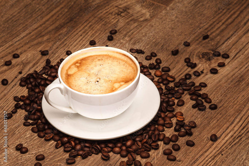 Obraz premium Coffee cup and saucer on a wooden table. with grains