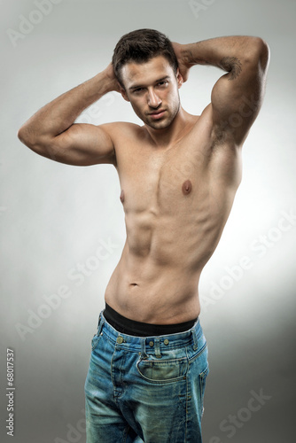 Handsome muscular man posing half naked