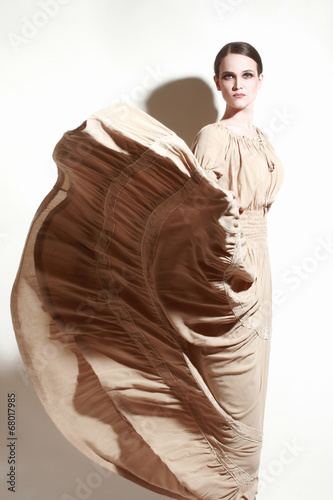 Elegant woman in flying dress. Fashion model in long dress photo