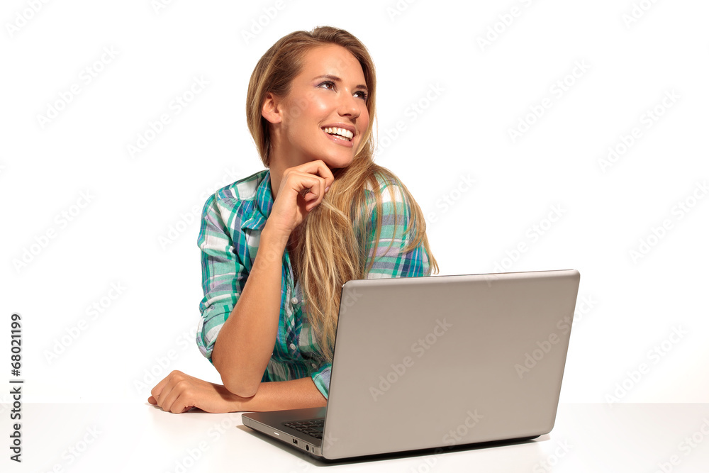 Happy  woman using laptop seated at the desk