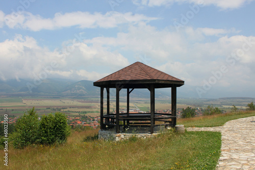 Wooden pavilion high above a small village © dianami6ko
