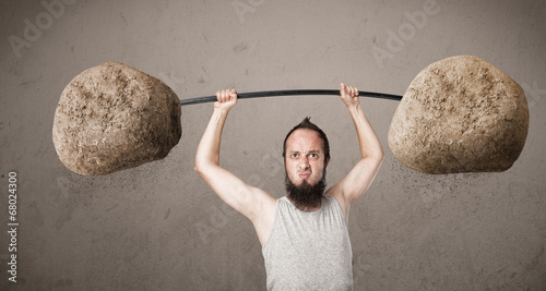 skinny guy lifting large rock stone weights