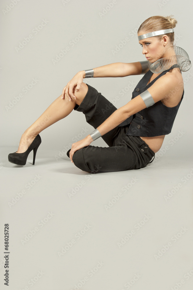 A young female model experimenting with fashionable elements in a studio setting. A young female model experimenting with fashionable elements in a studio setting.