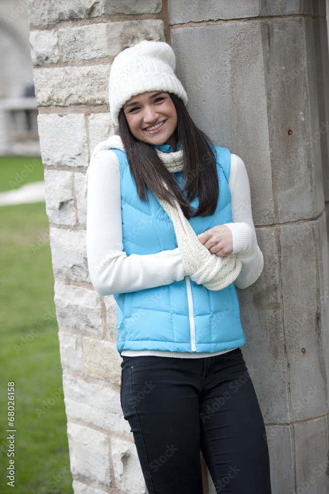 A happy young brunette girl wearing a white hand and a blue jacket on a sunny day. A happy young brunette girl wearing a white hand and a blue jacket on a sunny day.