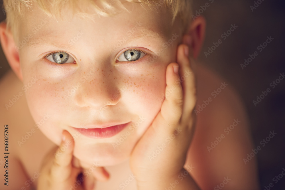 Cute young boy looking up with hands close to the face Cute young boy looking up with hands close to the face