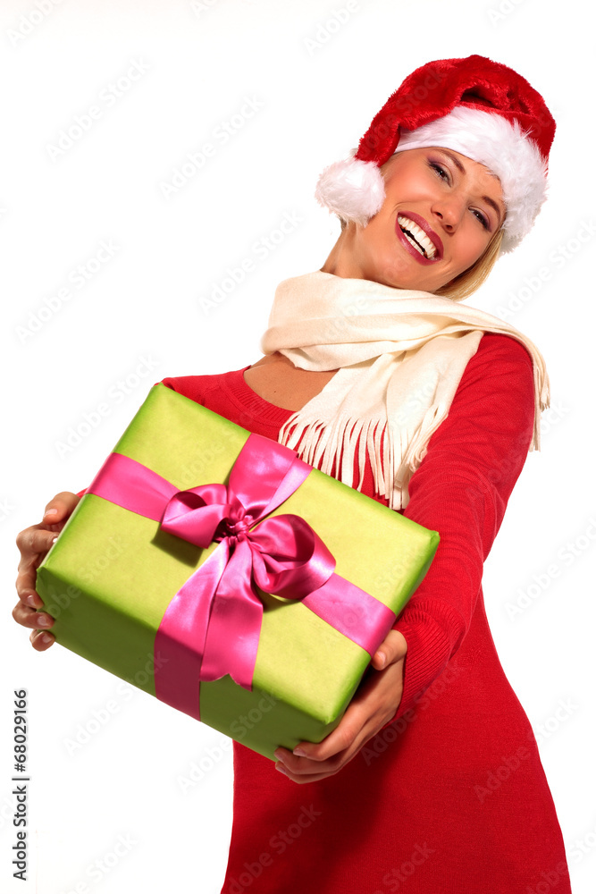 Happy girl showing a gift wearing santa claus hat