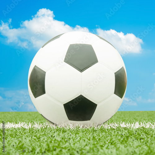 Soccer ball on the field with blue sky.