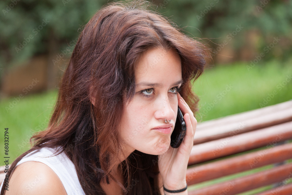 Furious girl talking on mobile phone. In the city. Furious girl talking on mobile phone. In the city.