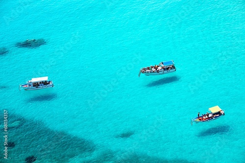 Small boats on the crystal clear sea © pitrs