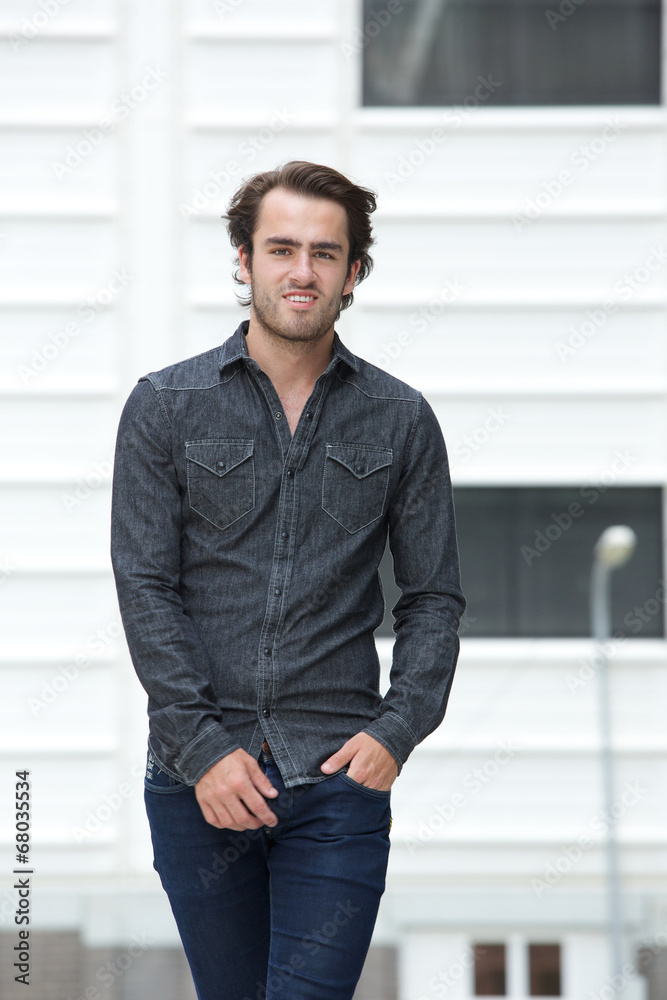 Confident young man walking outdoors Confident young man walking outdoors