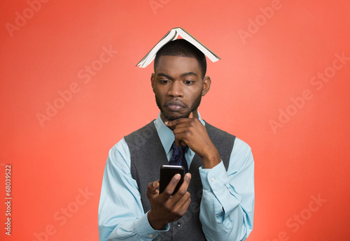 Man texting on mobile phone book over head confused  © pathdoc