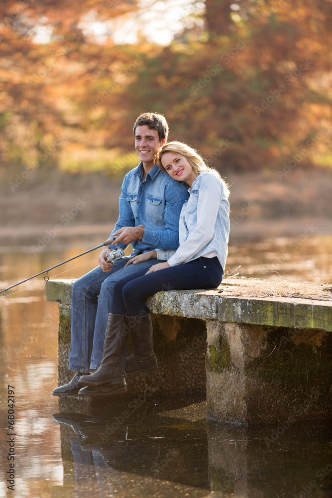 young man and girlfriend fishing on pier