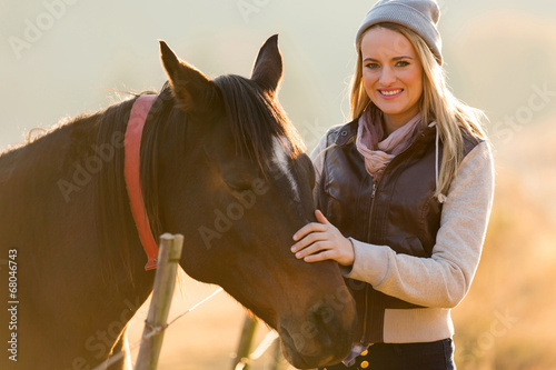 young woman petting horse