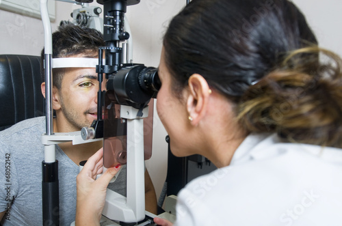 Optical exam to young man, professional woman photo