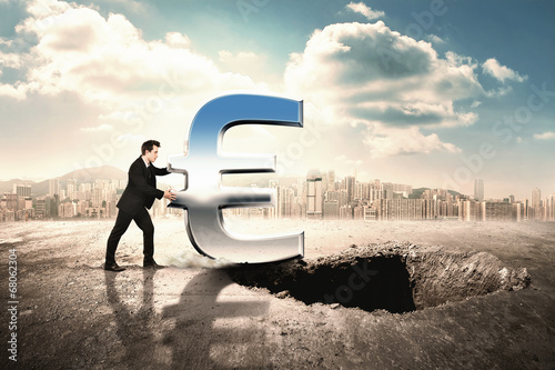 Fotografi Businessmen pushing icon of euro into a hole in the ground