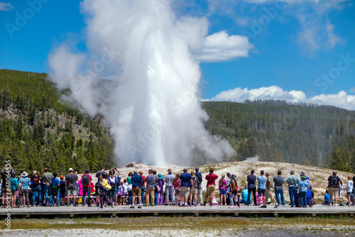 Fototapeta Tourists watching the Old Faithful erupting in Yellowstone Natio