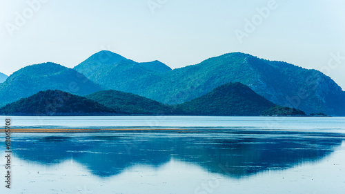 Calm sea with distant mountains and reflection in water