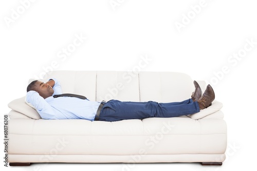 Businessman lying asleep on couch © WavebreakmediaMicro