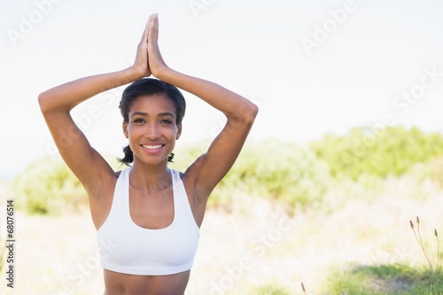 Fit woman sitting on grass in lotus pose smiling at camera © WavebreakMediaMicro