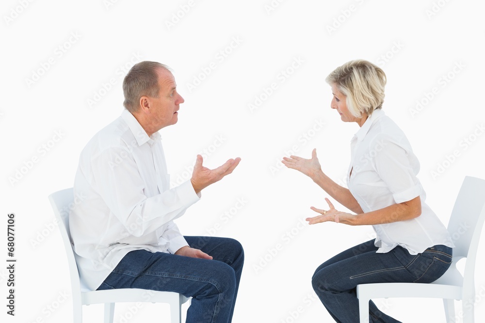Fototapeta premium Older couple sitting in chairs arguing