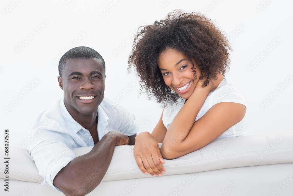 Couple sitting on couch together smiling at camera Couple sitting on couch together smiling at camera
